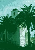 Mission-style church tower between palm trees