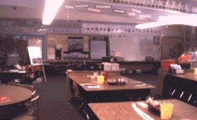 Elementary school classroom with tables and a whiteboard
